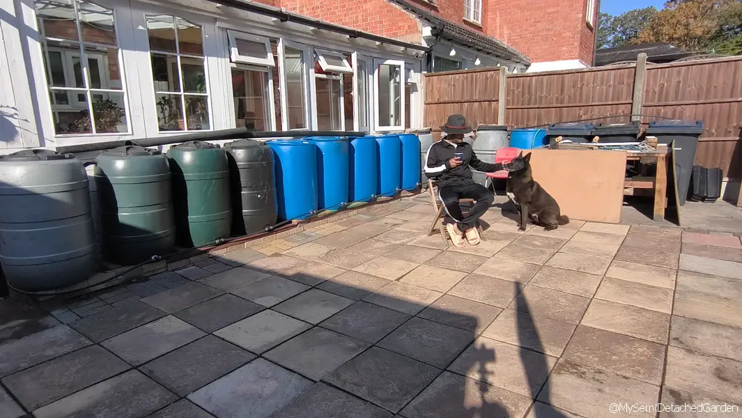 Finished 17-barrel rainwater harvesting system and off-grid gravity watering setup installed in a UK semi-detached garden